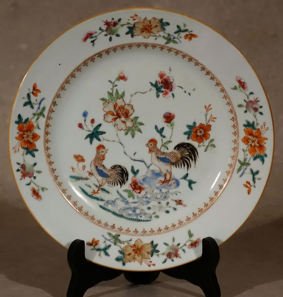 Assiette  en porcelaine de la Compagnie des Indes dite de commande décorée en émaux polychromes de la famille rose de deux coqs 