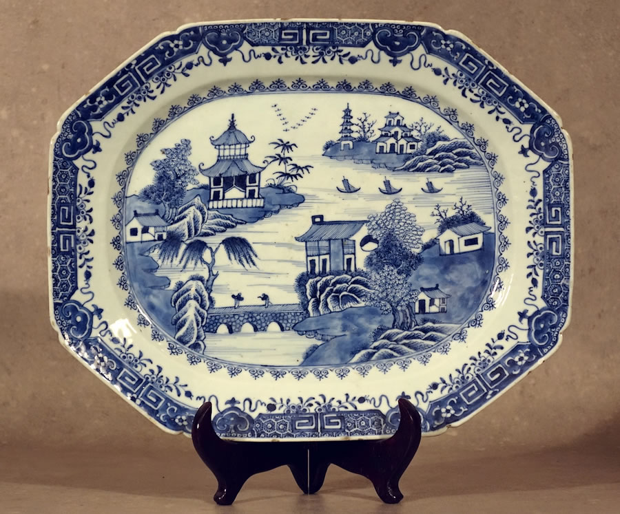Grand plat en porcelaine de Chine en camaïeu bleu sur fond blanc à décor d'un paysage lacustre à la pagode 18e