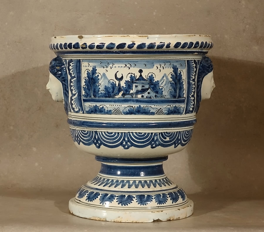 Petit vase à oranger en faïence de Nevers époque Louis XIV, forme Médicis sur piédouche, paysage oriental en camaïeu bleu et mascarons féminins